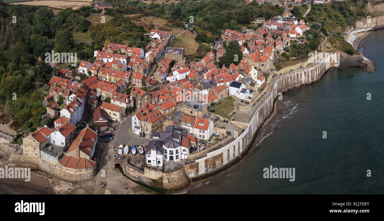 Vista panoramica aerea della Robin Hood's Bay sulla costa dello Yorkshire, Inghilterra, che mostra lo storico villaggio di pescatori con case dal tetto rosso e una strada tortuosa Foto Stock