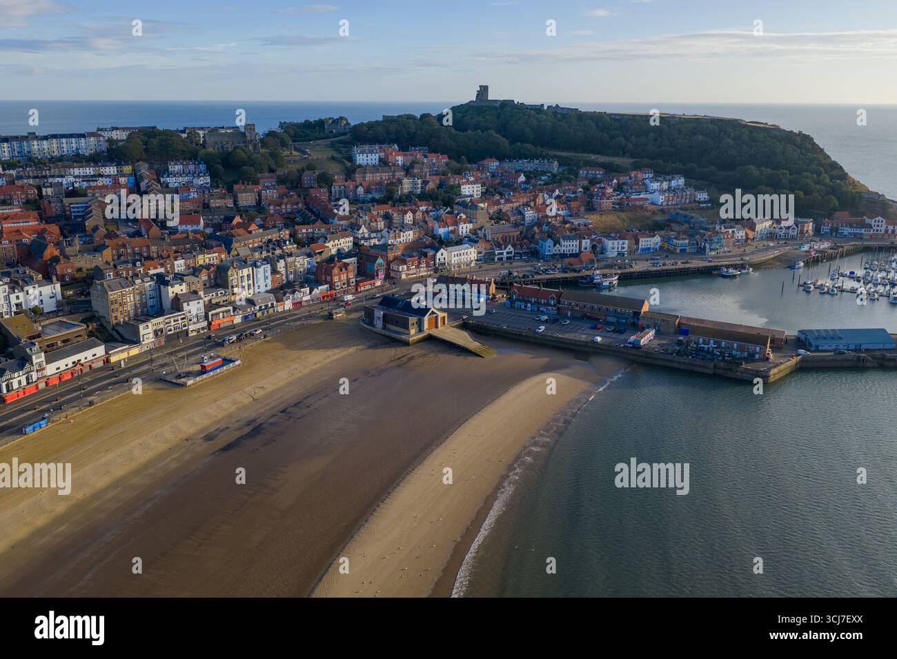 Vista aerea panoramica di Scarborough al mattino, con l'ampia spiaggia sabbiosa in primo piano, colorati edifici della città lungo il lungomare. Foto Stock