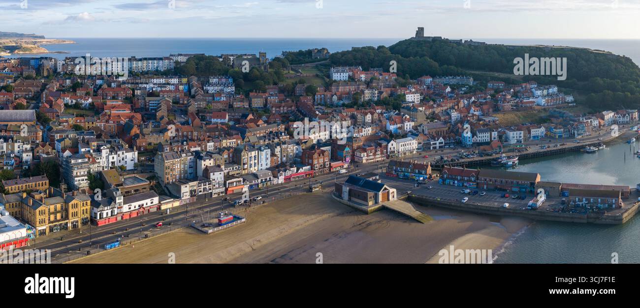 Vista aerea panoramica di Scarborough al mattino, con l'ampia spiaggia sabbiosa in primo piano, colorati edifici della città lungo il lungomare. Foto Stock