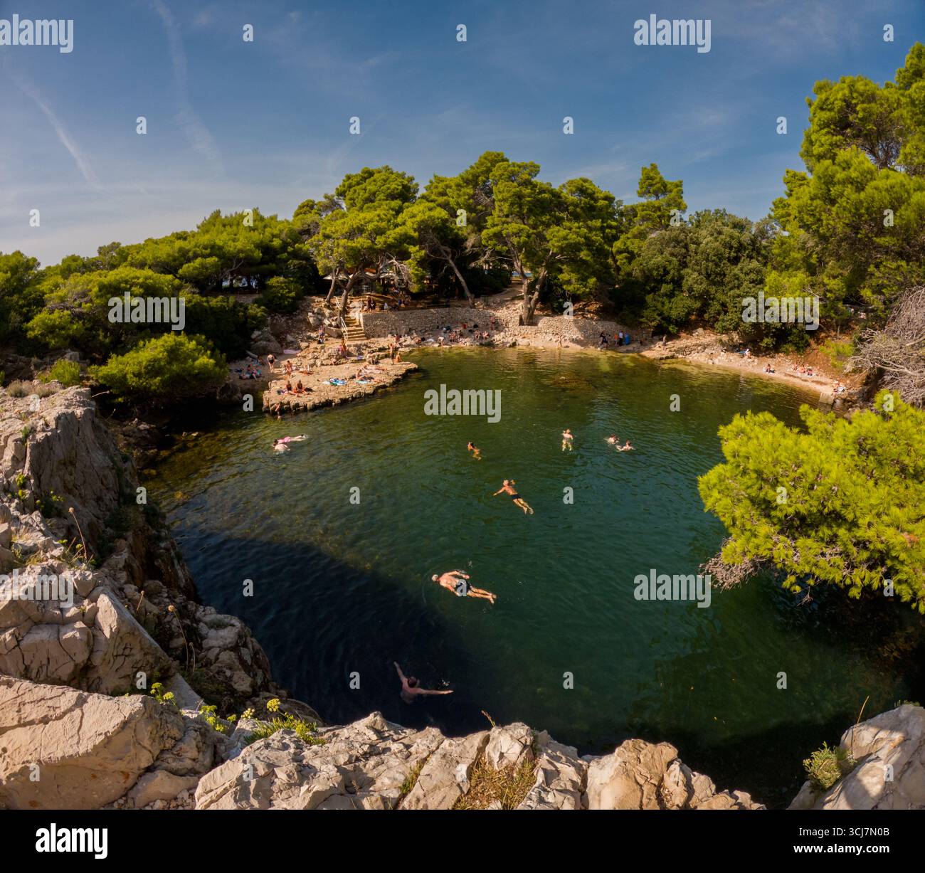 Isola di Lokrum, Dubrovnik, Croazia - 13 settembre 2023: I visitatori nuotano e si rilassano nel 'Mar morto', un popolare lago salato e un pozzo di nuoto sull'idillio Foto Stock