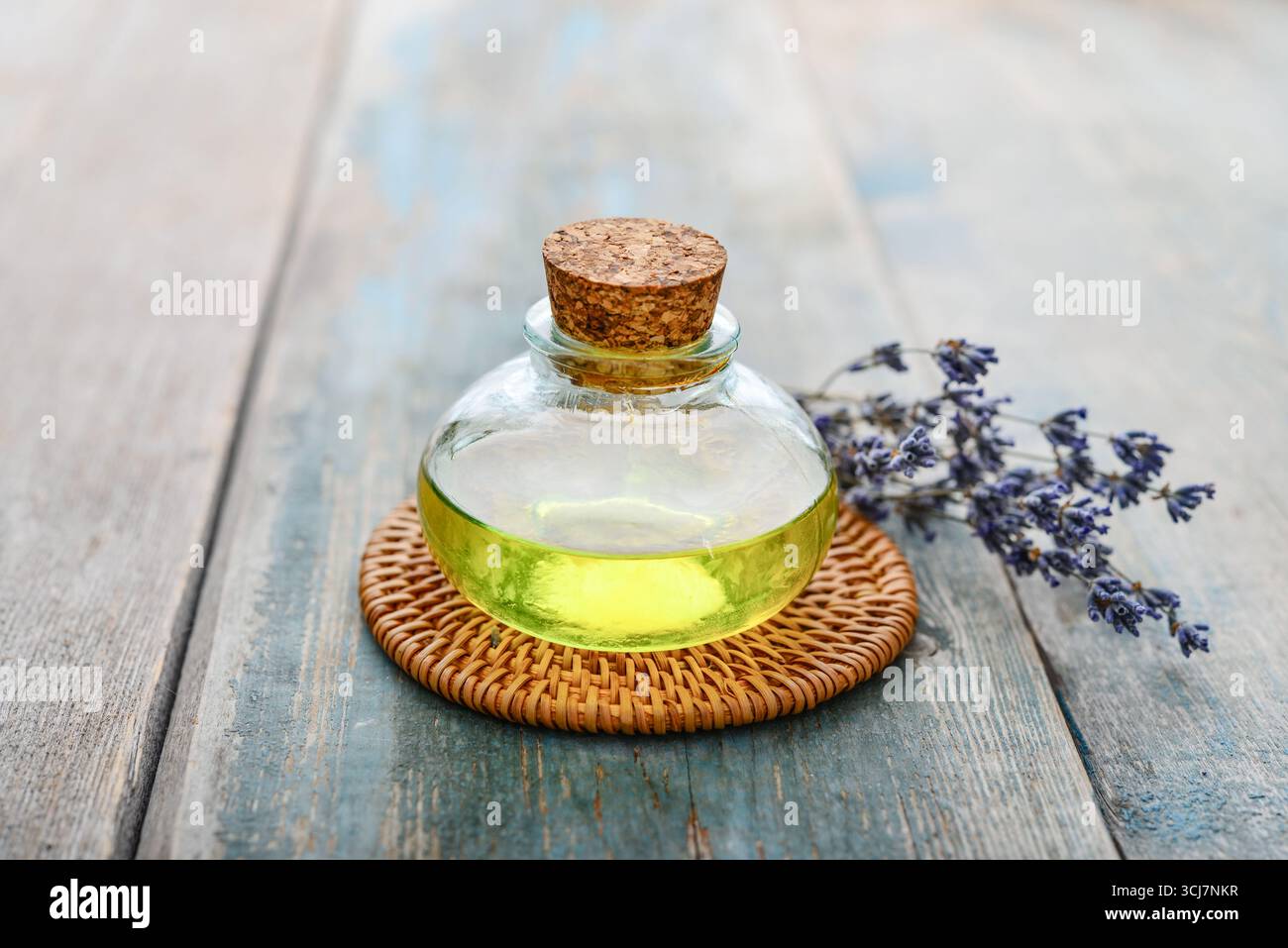 olio essenziale di lavanda in bottiglia di vetro con fiori di lavanda, cloceup. Concetto di medicina alternativa. Foto Stock