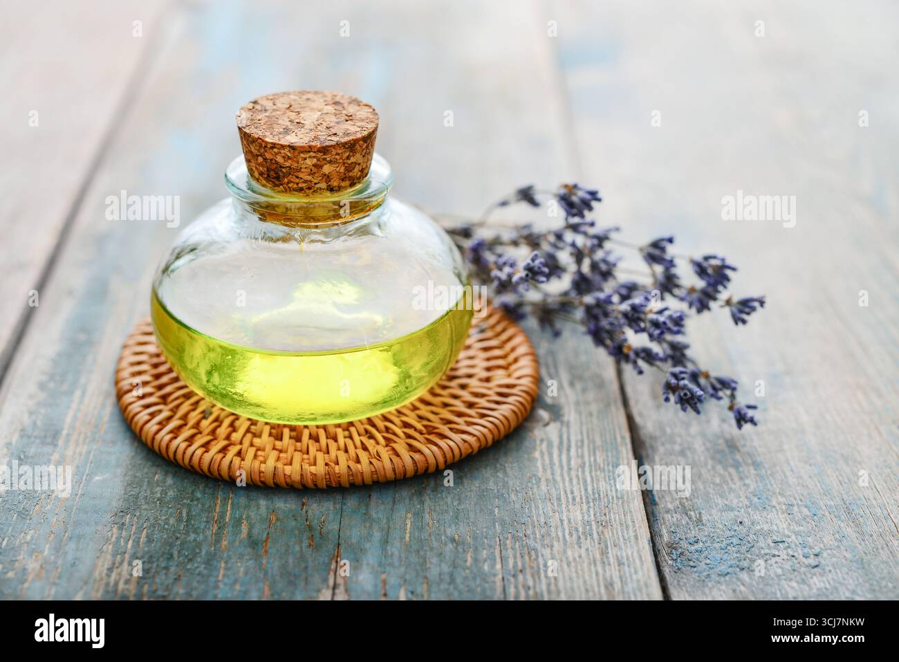 olio essenziale di lavanda in bottiglia di vetro con fiori di lavanda, cloceup. Concetto di medicina alternativa. Foto Stock