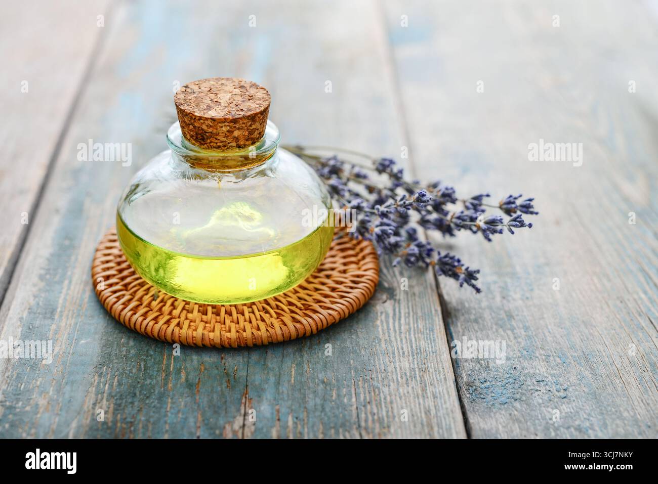 olio essenziale di lavanda in bottiglia di vetro con fiori di lavanda, cloceup. Concetto di medicina alternativa. Foto Stock