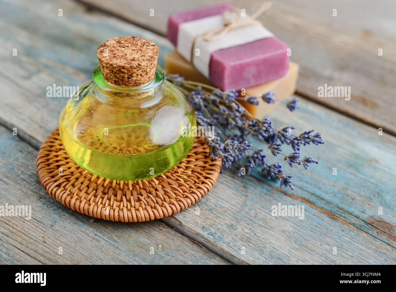 olio essenziale di lavanda in bottiglia di vetro con fiori di lavanda, cloceup. Concetto di medicina alternativa. Foto Stock