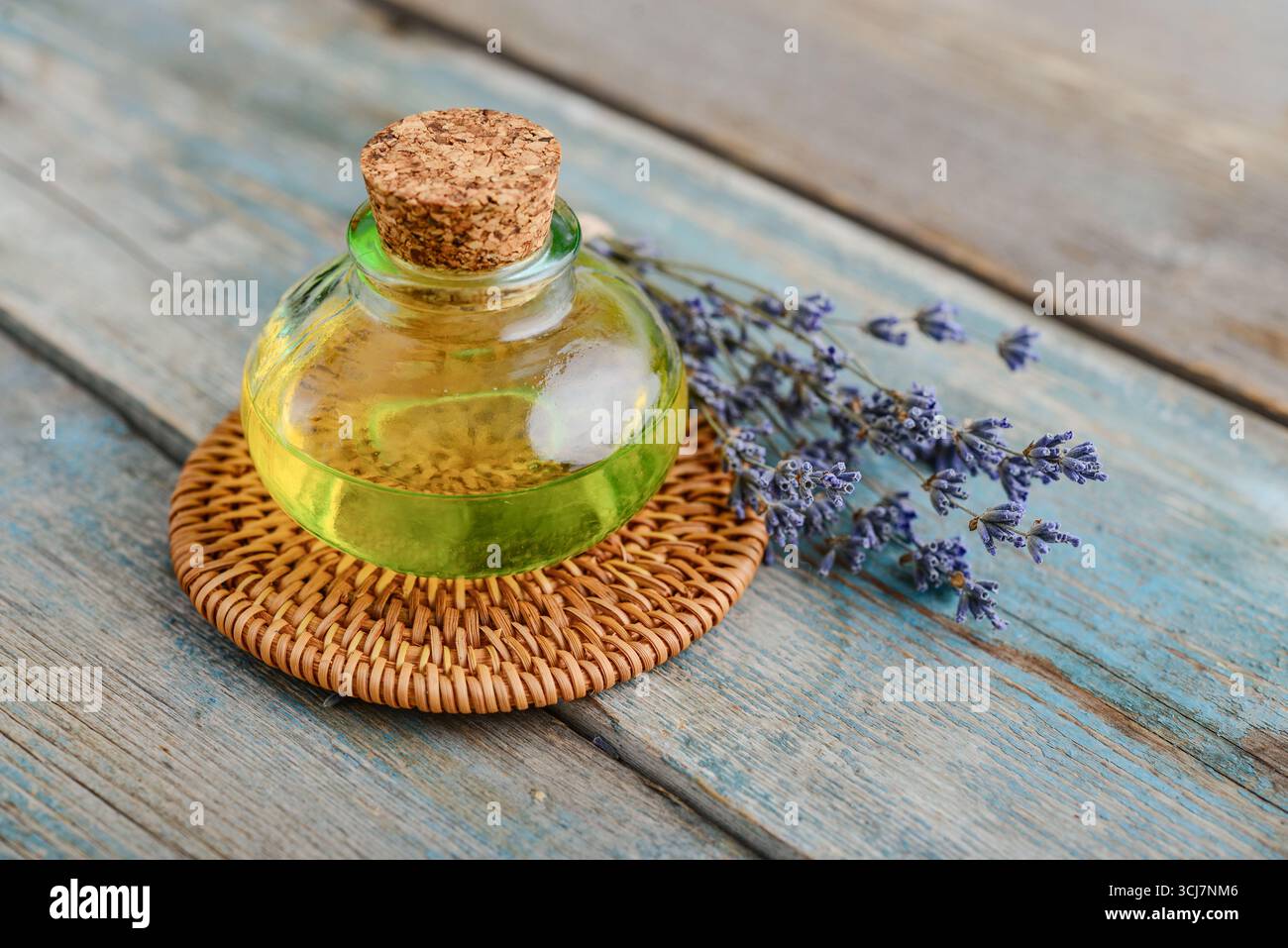 olio essenziale di lavanda in bottiglia di vetro con fiori di lavanda, cloceup. Concetto di medicina alternativa. Foto Stock