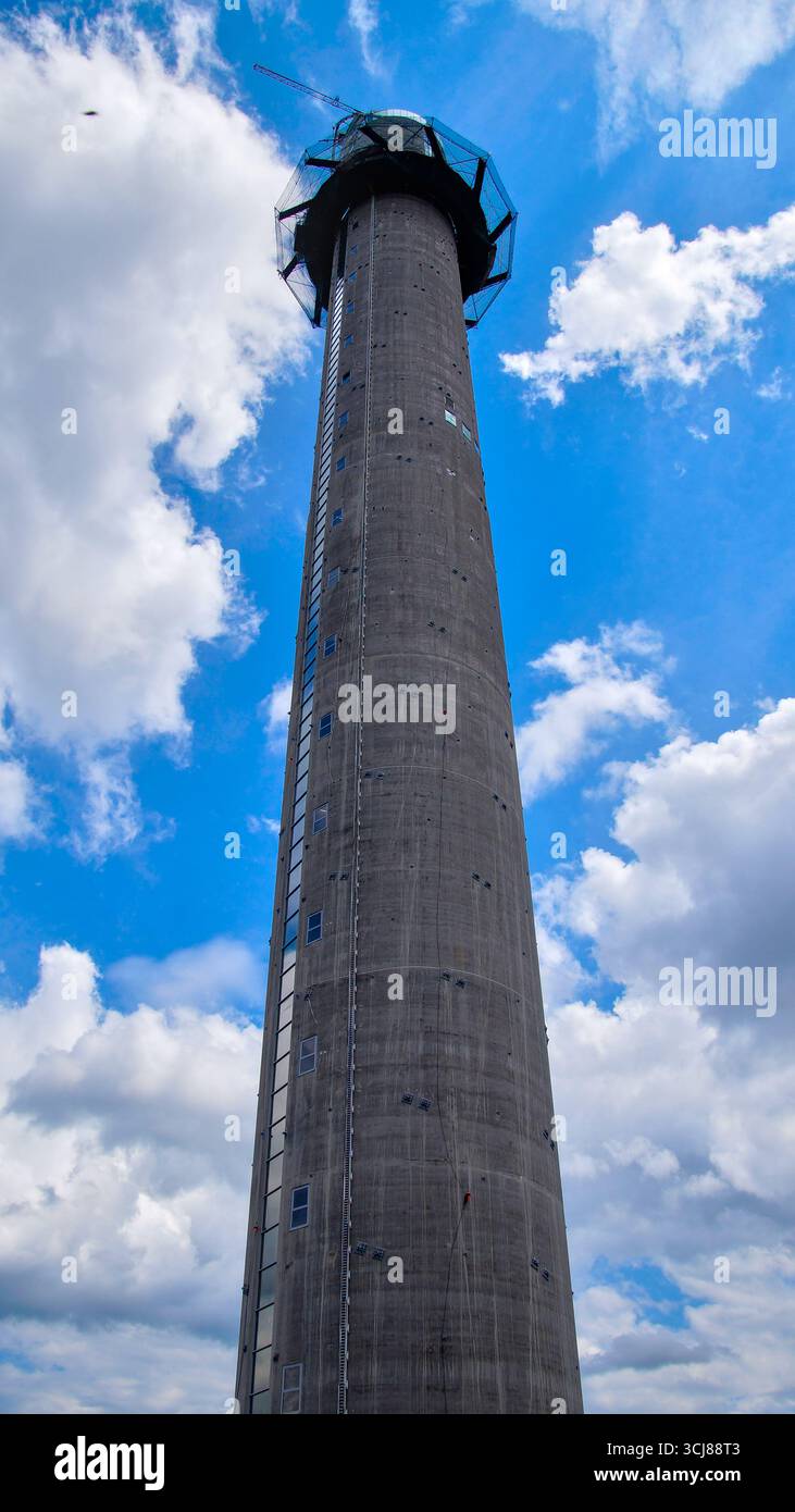 Torre in costruzione con un cielo parzialmente nuvoloso e macchie di blu. Foto Stock