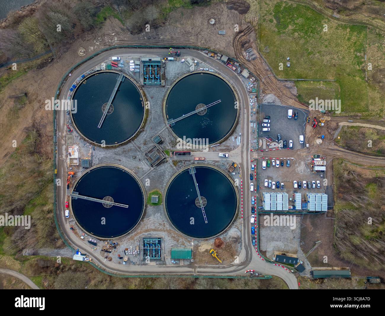 Panoramica di un impianto di trattamento delle acque reflue che presenta serbatoi circolari e infrastrutture circostanti Foto Stock