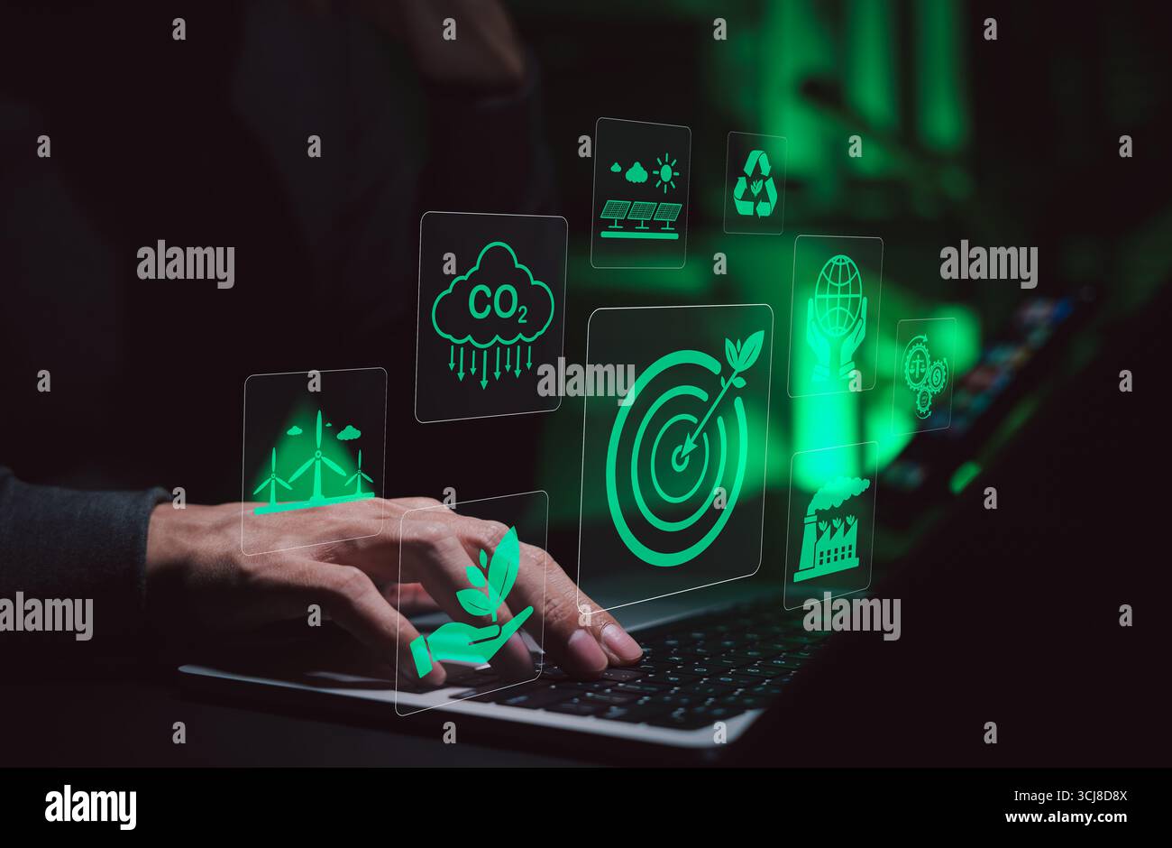 Tecnologia sostenibile e innovazione dell'energia verde. Persona che utilizza un computer portatile con icone verdi che rappresentano energia rinnovabile, riduzione di CO2, riciclaggio, Foto Stock