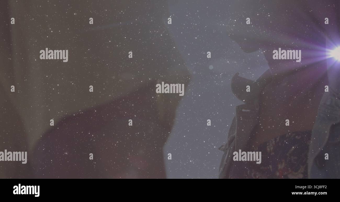 Con una sorgente luminosa rivestita in denim, un uomo che illumina il corridoio dietro le quinte con un bagliore viola della lente, spazio copia Foto Stock