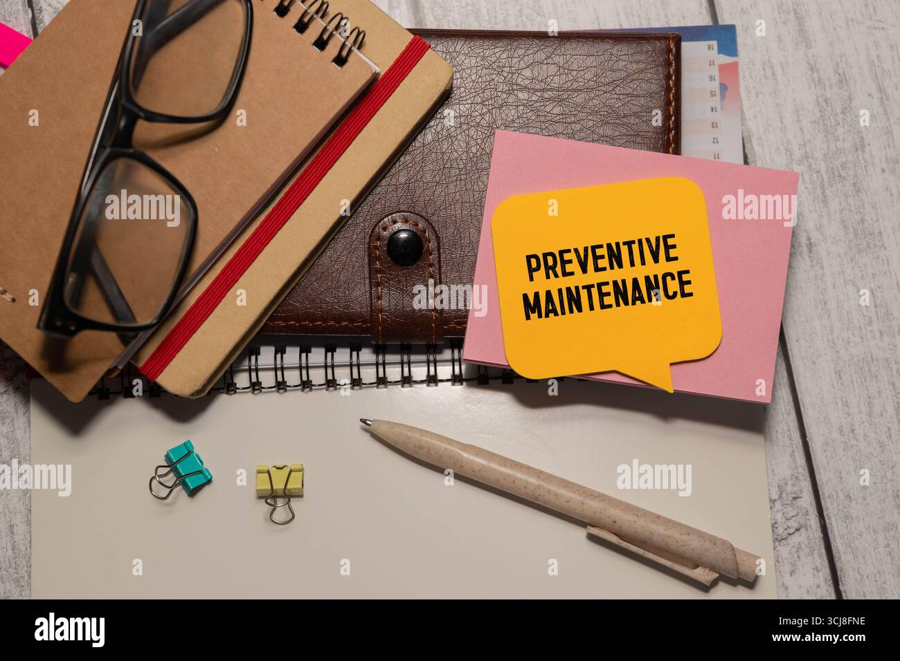 Testo sulla manutenzione preventiva scritto su carta con lente d'ingrandimento Foto Stock