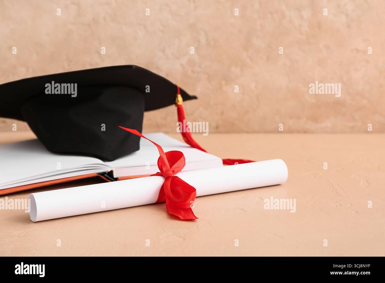 Diploma con libro e mortaio su sfondo beige Foto Stock