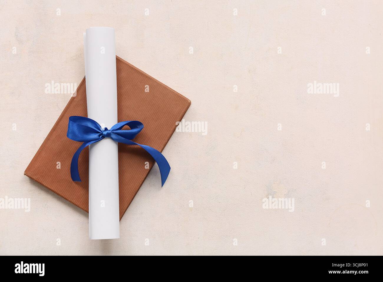 Diploma con nastro blu e libro su sfondo bianco Foto Stock