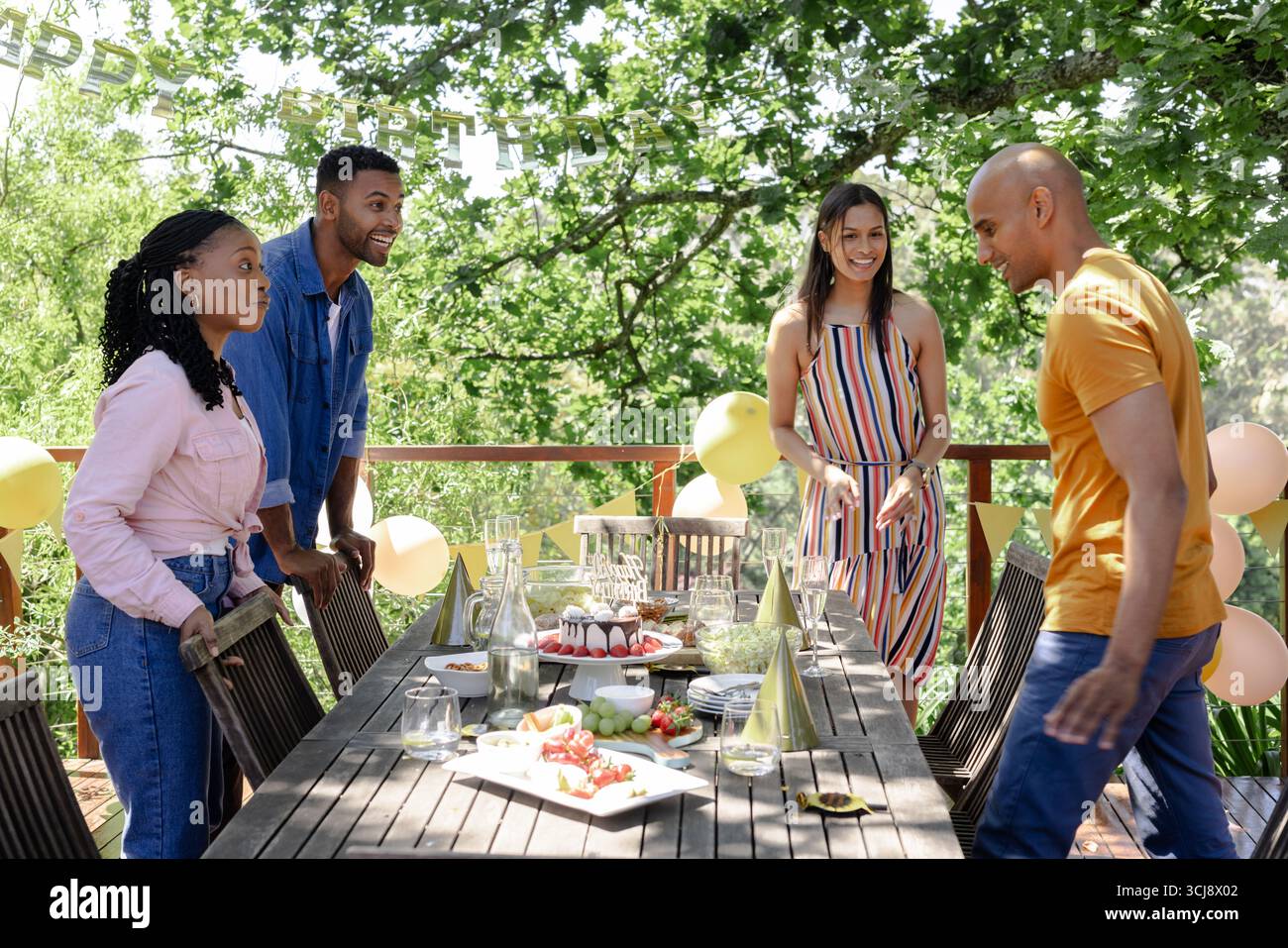 Amici che festeggiano il compleanno all'aperto con cibo e decorazioni nelle giornate di sole Foto Stock