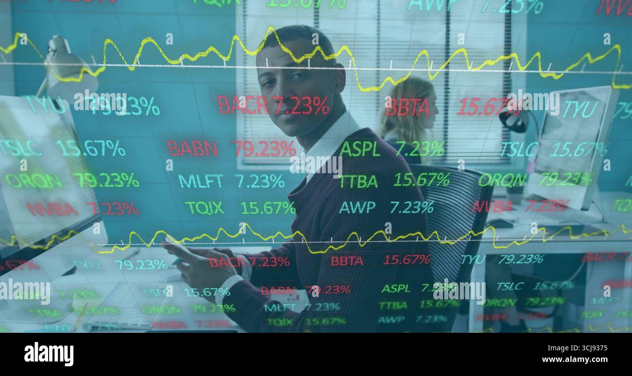 Uomo del Sud Asiatico che indossa un dispositivo di custodia casual per affari che guarda i biglietti azionari alla scrivania con la tastiera Foto Stock