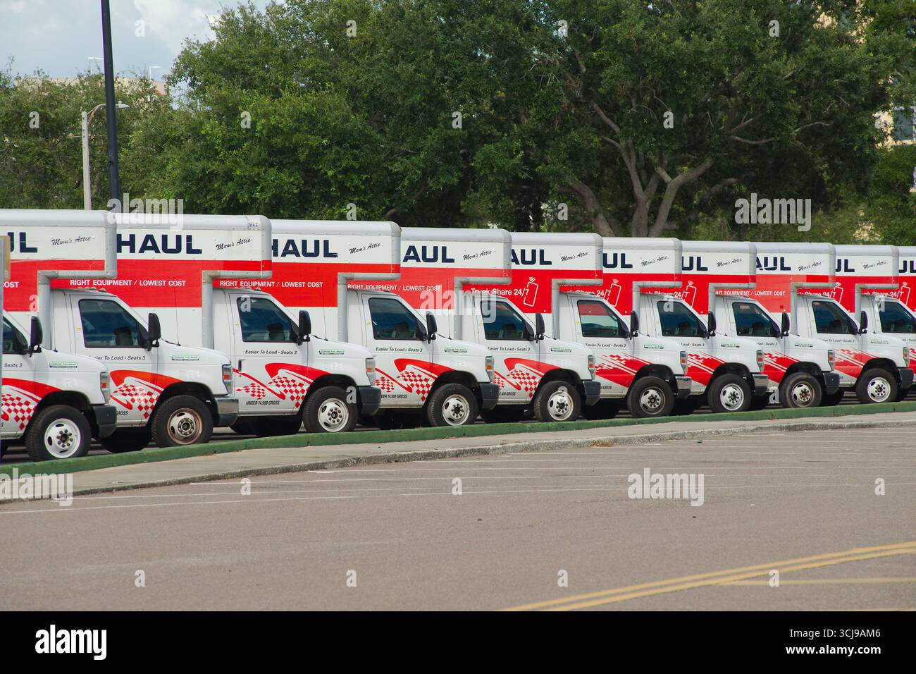 Fila di dumper in movimento U-Haul in un parcheggio. Uso editoriale solo 2 settembre 2025 St. Petersburg, Florida, USA. Linea di veicoli U-Haul parcheggiati esternamente Foto Stock