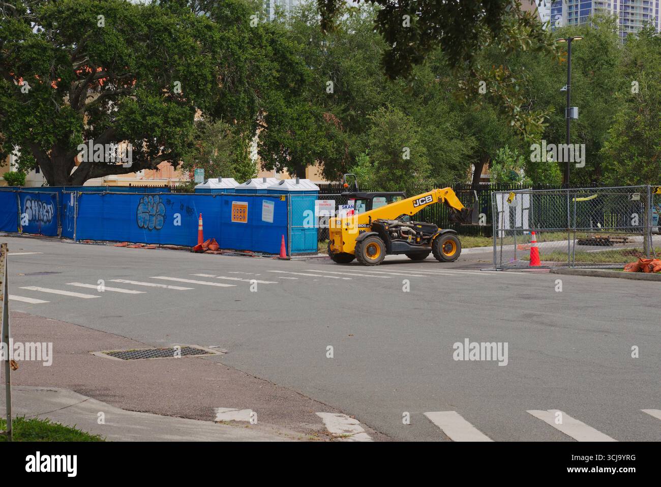 Veicoli da cantiere che trasportano materiali in un cantiere all'aperto. Uso editoriale solo 4 settembre 2025 St. Petersburg, FL USA. Trasporto pallet materi Foto Stock