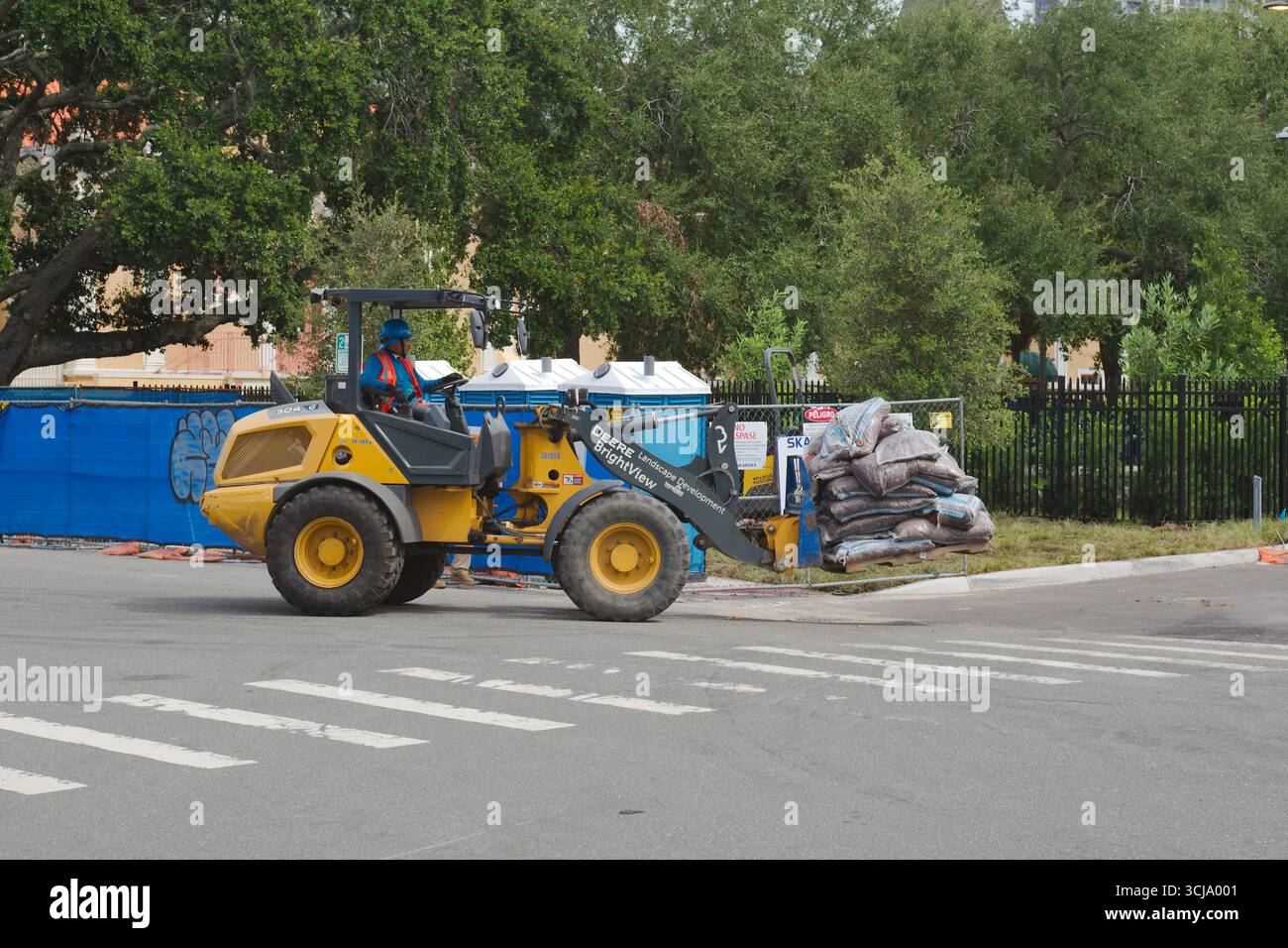 Veicoli da cantiere che trasportano materiali in un cantiere all'aperto. Uso editoriale solo 4 settembre 2025 St. Petersburg, FL USA. Trasporto pallet materi Foto Stock