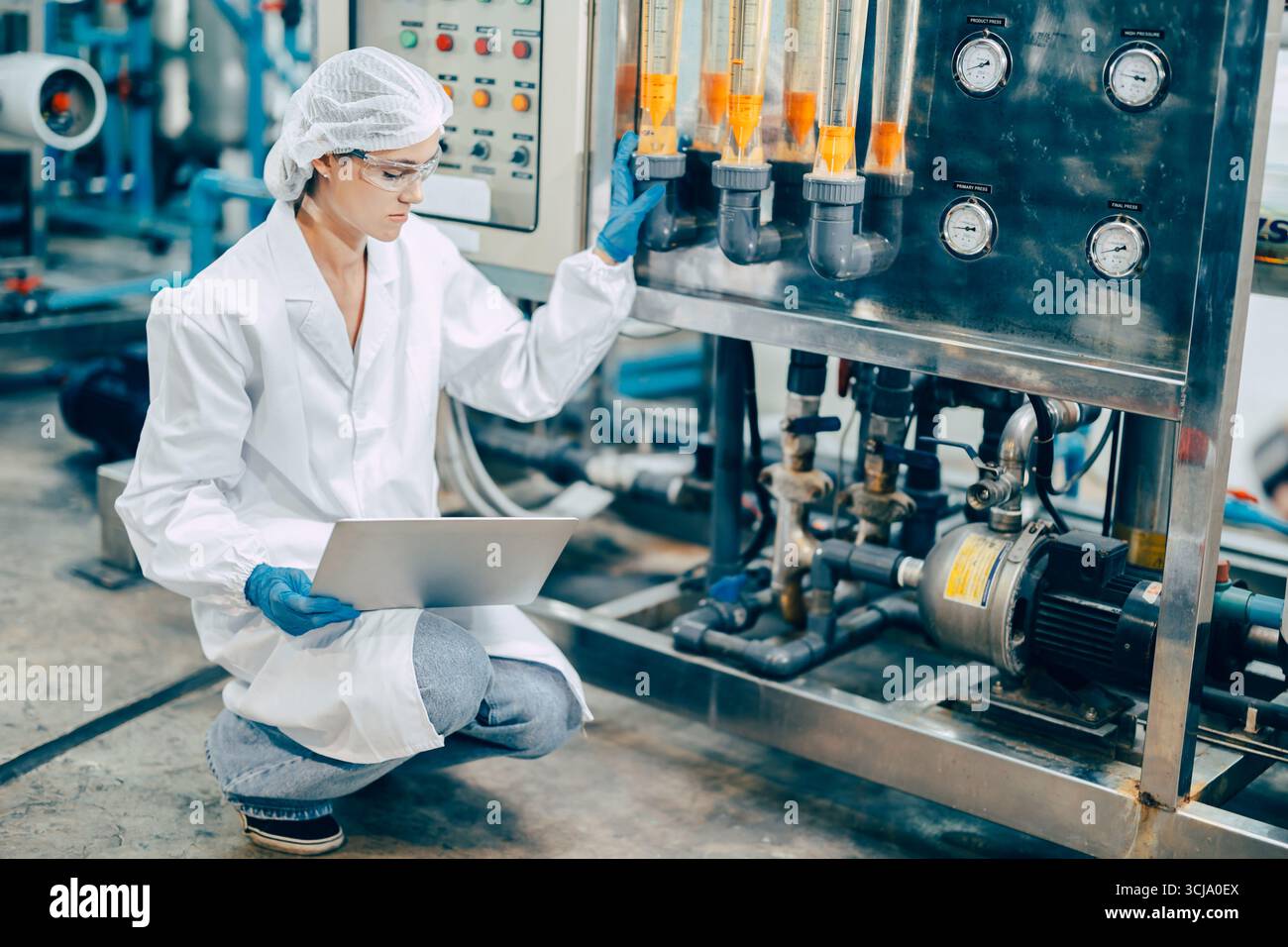 personale mano lavoro in scienza laboratorio medico fabbrica controllare record serbatoio di pressione con computer portatile Foto Stock