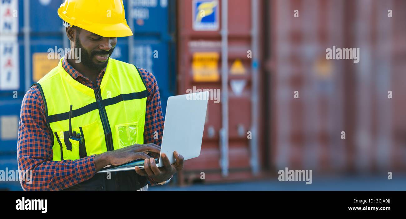 Uomo nero africano che lavora nel porto di spedizione di container, dogana nel deposito di container con computer portatile per lo sfondo di banner del settore logistico. Foto Stock