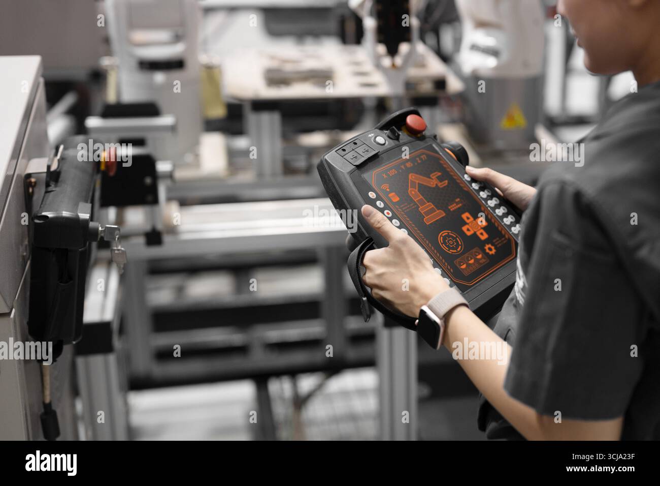 Primo piano ingegnere che utilizza la configurazione robotizzata industriale controlla il controllo tramite telecomando in un moderno stabilimento Foto Stock