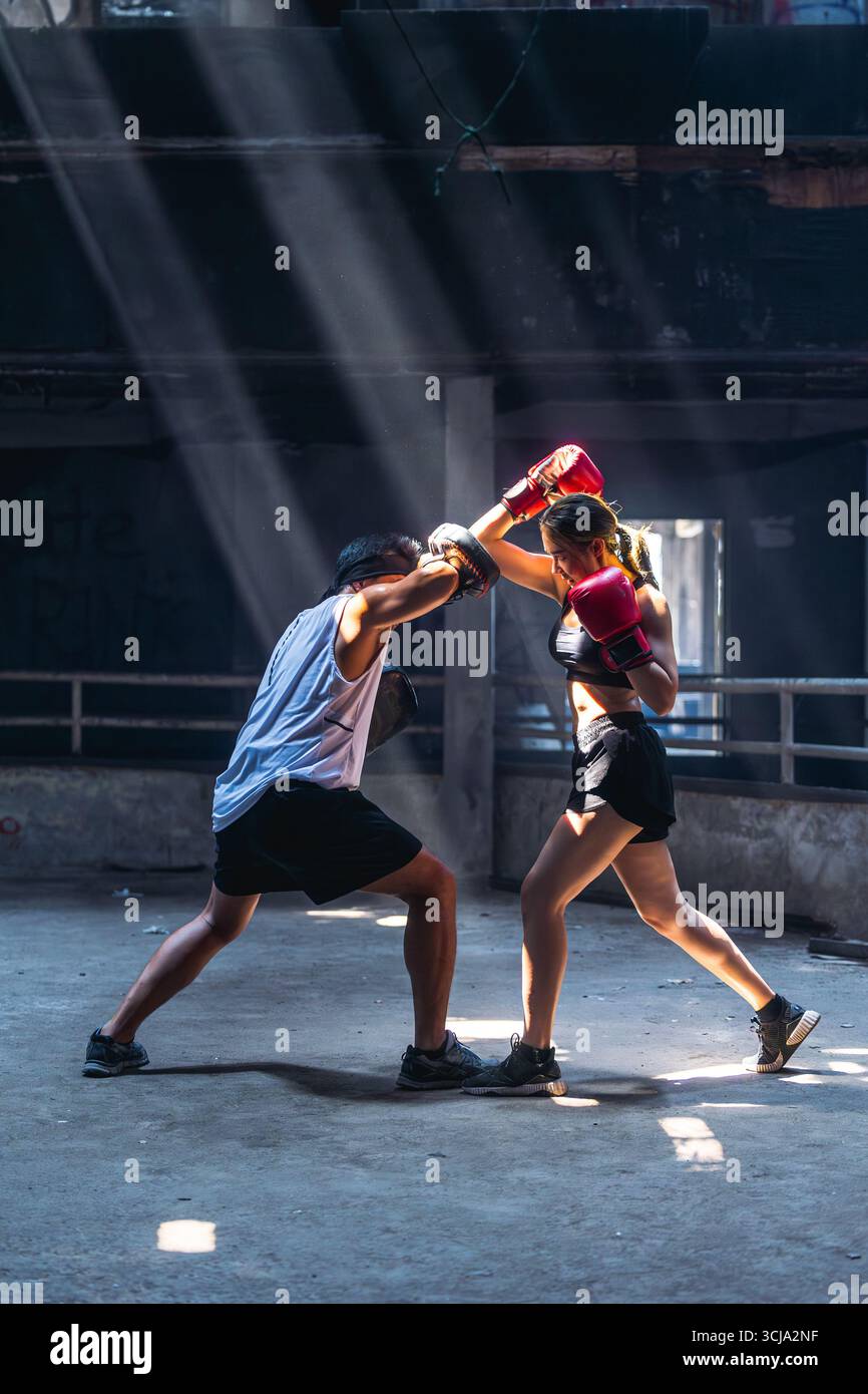 Pugilato thailandese, Muay thailandese, allenamento di pugilato femminile con allenatore in rovina, scena di combattimento di arti marziali asiatiche Foto Stock