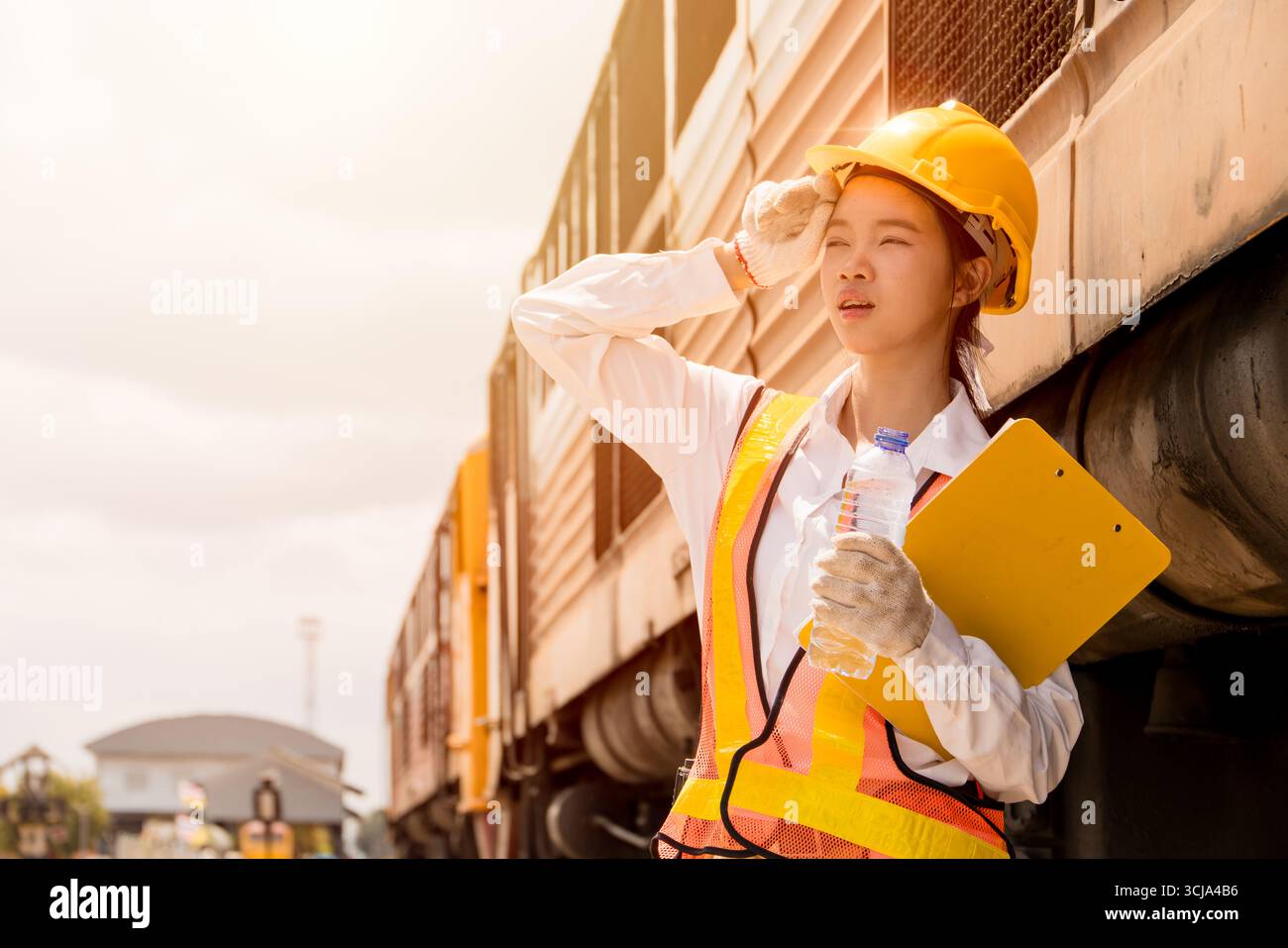 La giovane lavoratrice si sente stanca stanca stanca stanca e stanca suda a causa dei raggi UV caldi all'aperto duramente lavorati nelle giornate estive e al sole pericolo di colpo di calore Foto Stock