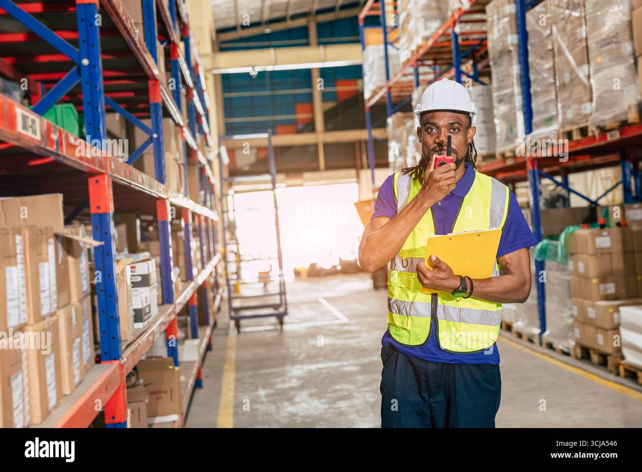 il lavoratore del personale di magazzino lavora nel magazzino merci per la logistica il settore della fornitura di prodotti di spedizione, le comunicazioni radio Foto Stock