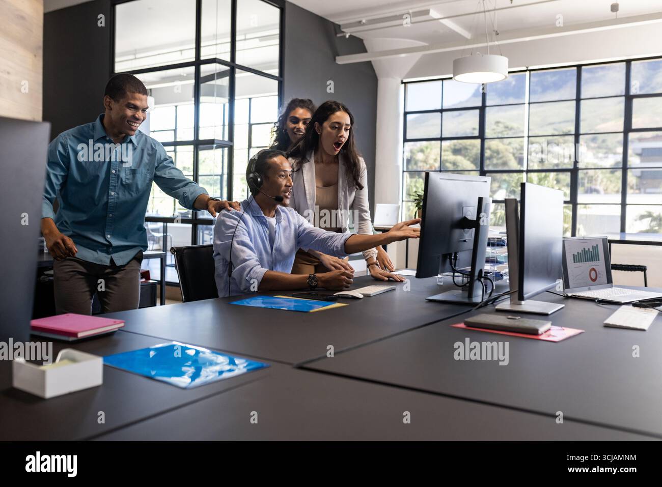 Team aziendali diversificati che collaborano e discutono di progetti presso una moderna scrivania Foto Stock