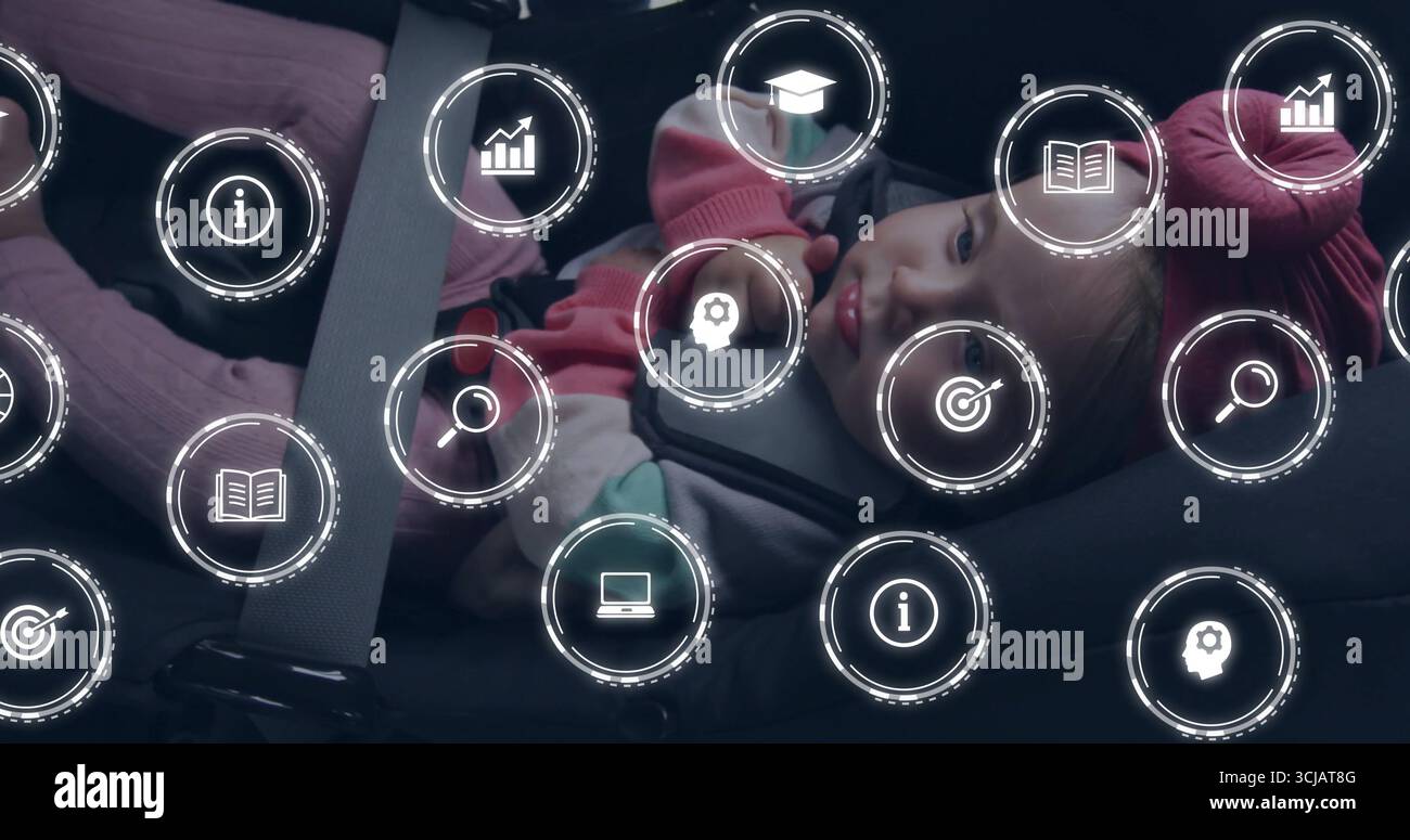 Una bambina seduta che indossa un cappello rosa con guanti in giacca grigia in auto, con imbracatura per il sedile e icone digitali Foto Stock