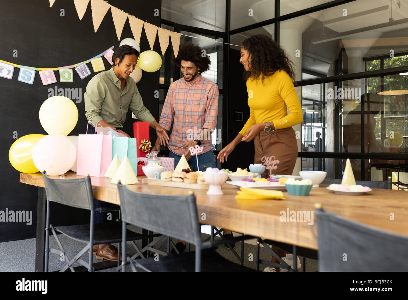 Festeggiamo la baby shower, i colleghi organizzano regali e decorazioni in ufficio Foto Stock