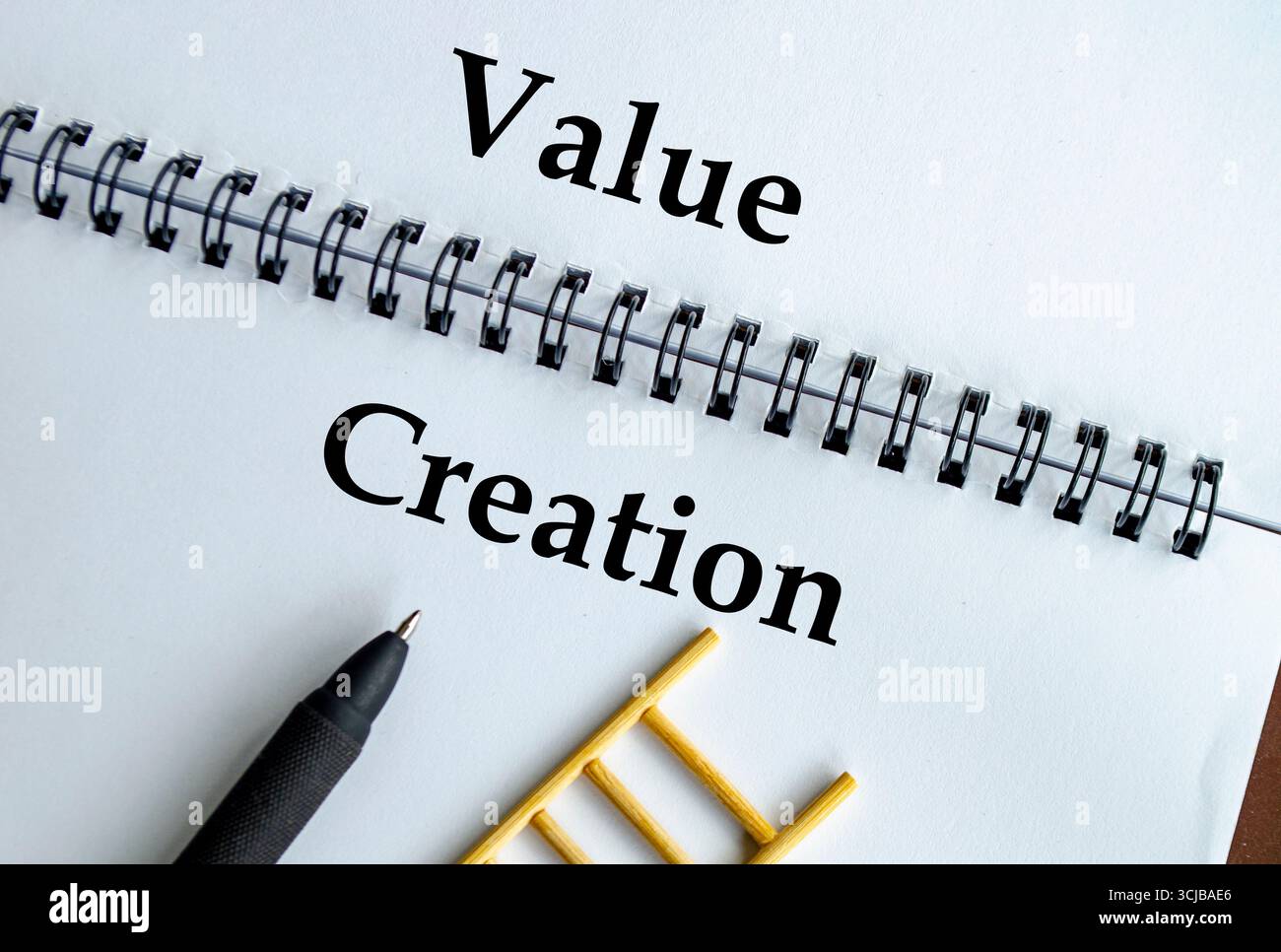 Creazione di valore, notebook con illustrazione a scala che rappresenta innovazione, crescita e impatto sostenibile Foto Stock