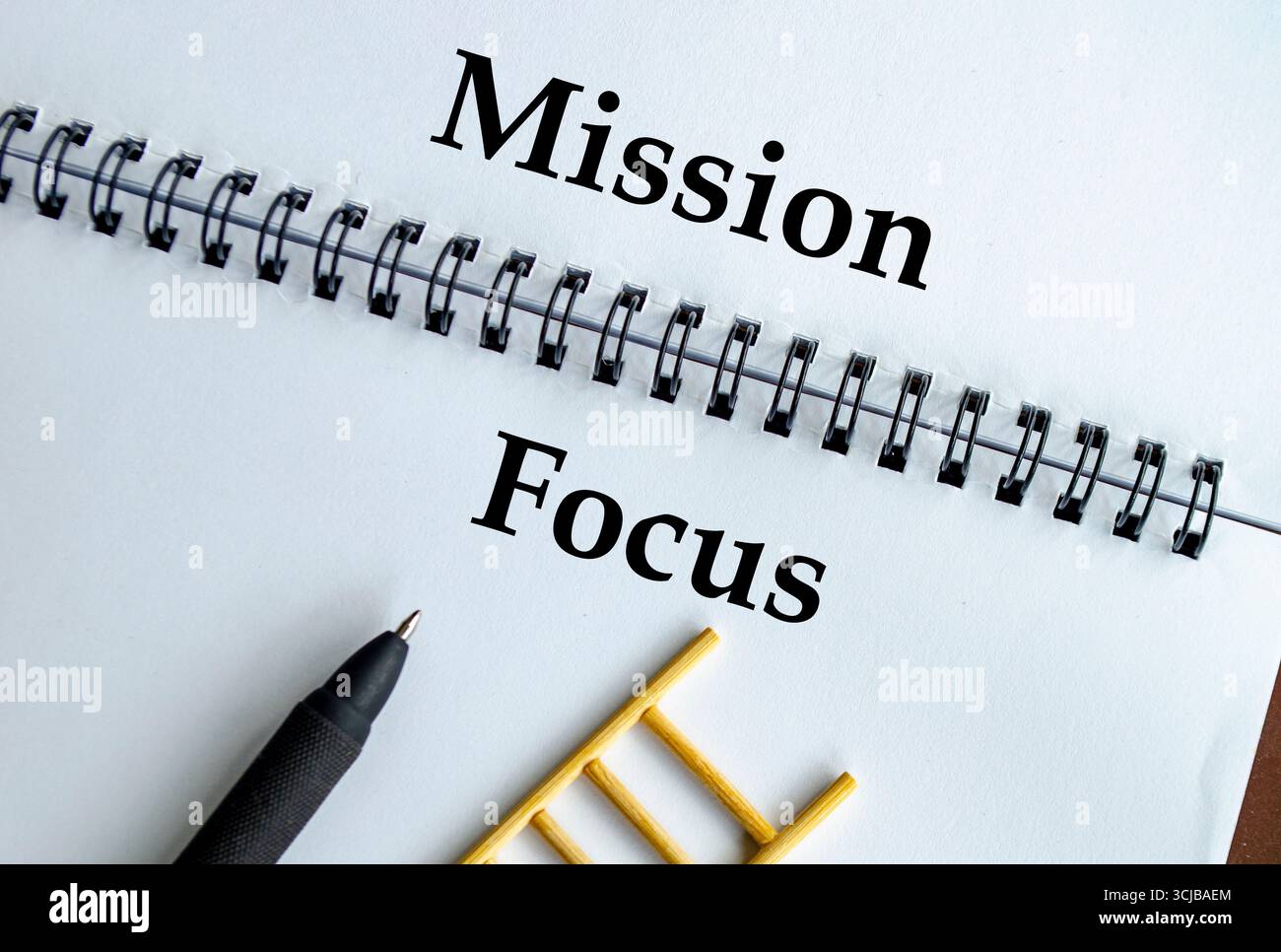 Mission Focus, notebook con illustrazione a scala che simboleggia lo scopo, la dedizione e le strategie orientate agli obiettivi Foto Stock