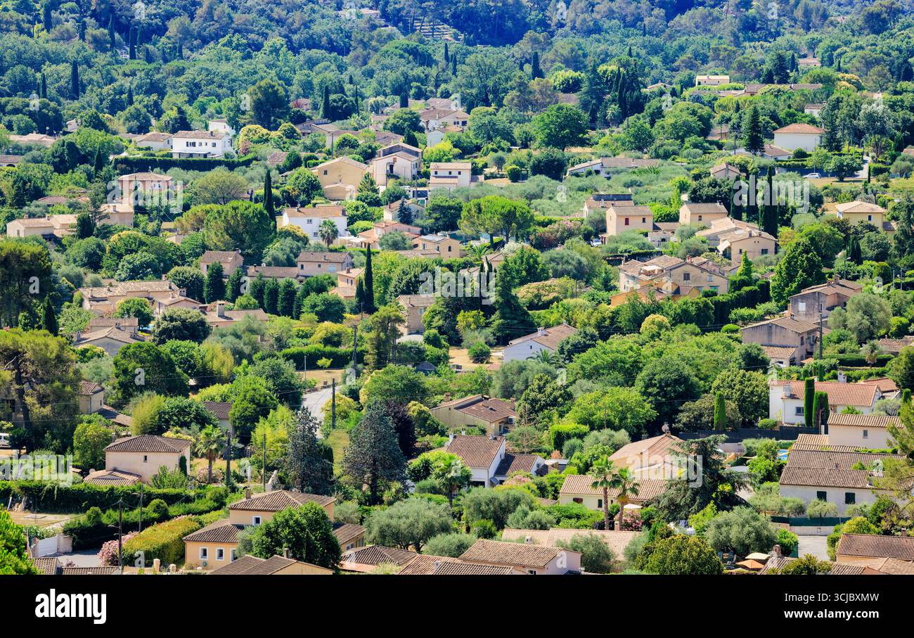 Zona residenziale a Grasse con case, giardini mediterranei e tetti di terracotta nel paesaggio collinare della Francia meridionale - immobili provenzali nel verde Foto Stock