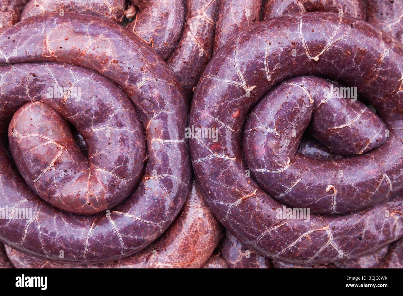 Una grande pila di salsicce tradizionali condite con spezie, da vicino Foto Stock