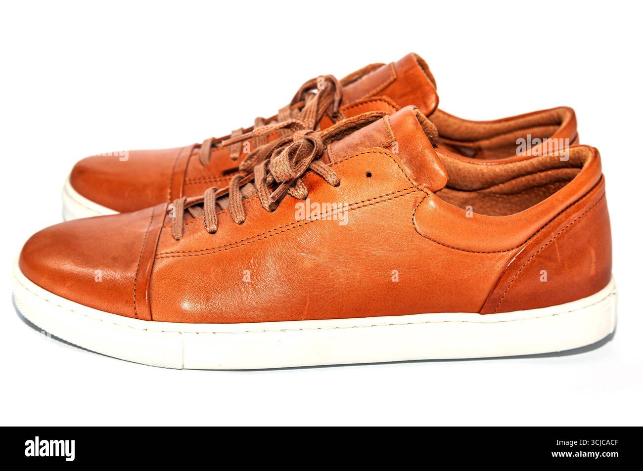 Scarpe giovani da uomo in pelle di colore marrone con suola bianca su sfondo bianco. Foto Stock