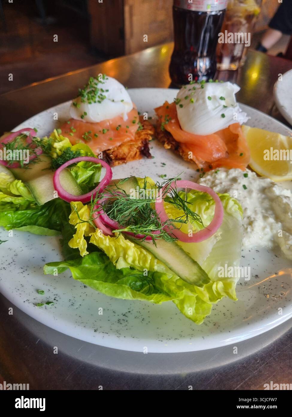 Brunch classico con uova benedict con salmone affumicato, uova in camicia, salsa hollandaise e insalata. - Immagine stock catturata con smartphone
