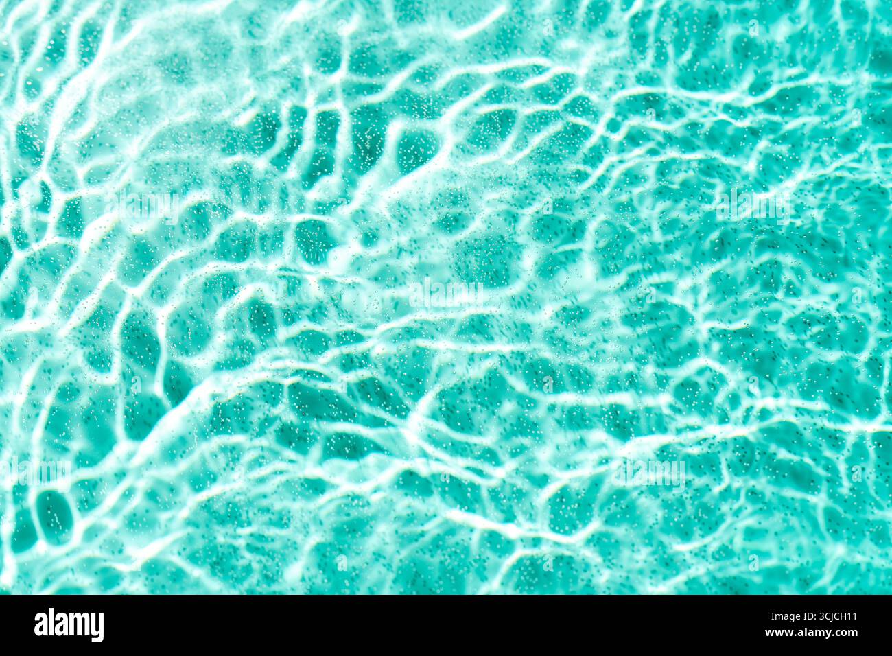 La superficie dell'acqua turchese chiara mostra intricati motivi di onde ondulate e riflessi luminosi scintillanti. La trama aggiunge profondità e movimento, cre Foto Stock