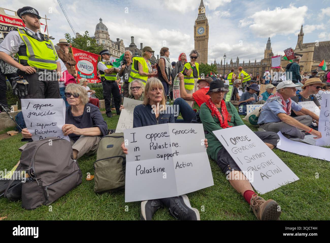 Londra, Regno Unito. 6 settembre 2025. I manifestanti si riuniscono pacificamente sull'erba fuori dal Palazzo di Westminster a Londra, con il Big Ben visibile sullo sfondo. I partecipanti hanno segnali che si oppongono al genocidio e che esprimono solidarietà alla Palestina e all’azione palestinese. Gli agenti di polizia osservano la manifestazione. Difendere la protesta delle nostre giurie per la proscrizione dell’azione contro la Palestina, con oltre 1000 persone che si impegnano a tenere dei segnali contro il divieto dei laburisti e a dimostrare sostegno al gruppo proscritto. Penelope Barritt/Alamy Live News Foto Stock