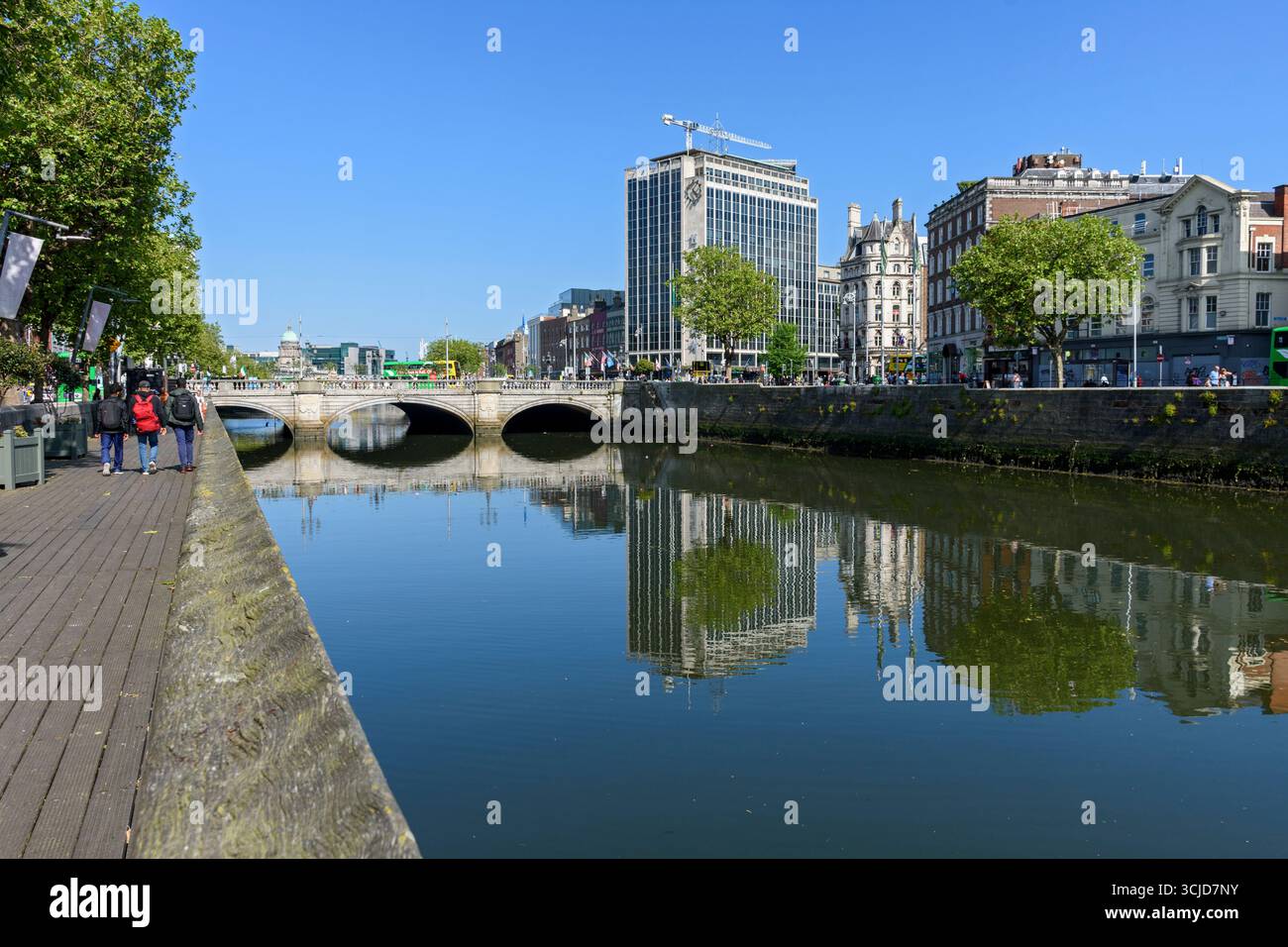 Il ponte o'Connell e la o'Connell Bridge House si riflettono nel fiume Liffey. Dublino, Irlanda. Edificio progettato da Desmond FitzGerald, 1964. Foto Stock