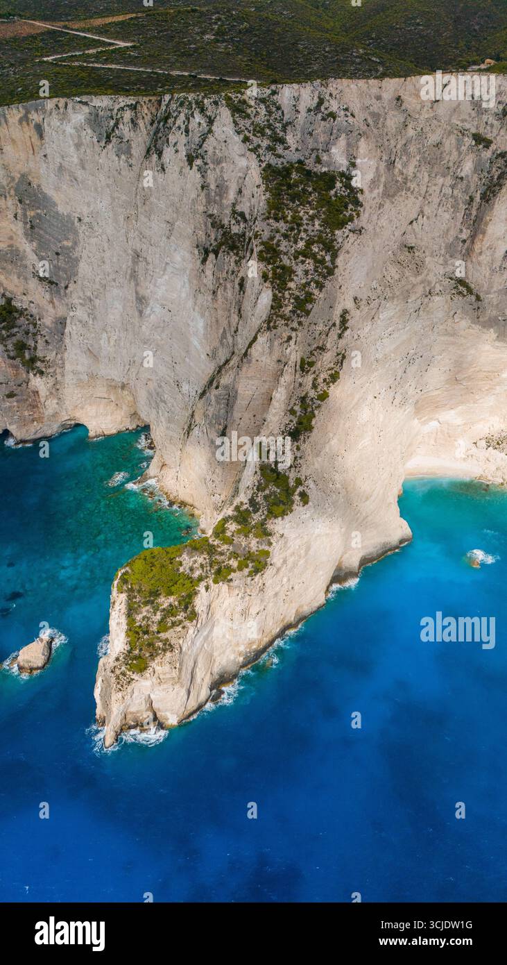 Zante Grecia, Spiaggia Bianca, vista aerea delle scogliere calcaree che torreggiano sul turchese Mar Ionio con una piccola baia rocciosa che crea un paesaggio epico Foto Stock