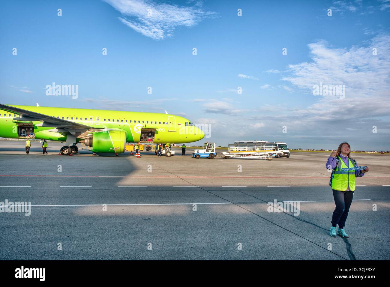 Abakan, Russia - 8 agosto 2020: Fotografo di un team di avvistamento sullo sfondo di un aereo con un hash tag all'aeroporto. Foto Stock