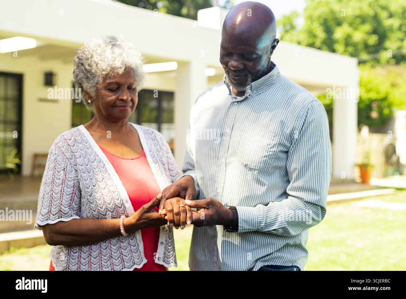 Coppia di anziani che si scambiano anelli all'aperto, celebrando l'amore e l'impegno insieme Foto Stock