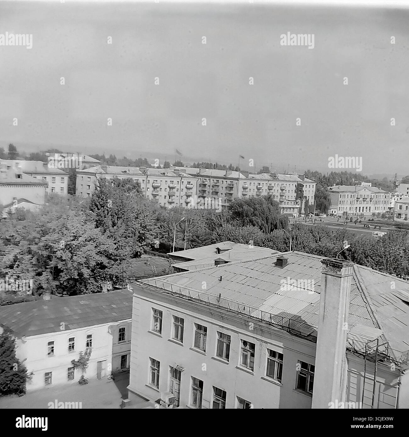 Una vista panoramica della piazza centrale della Rivoluzione d'ottobre (ora piazza Soborna) nella città di Slavyansk durante la seconda metà degli anni '1970, che mostra il cuore di una città sovietica nell'era della stagnazione: L'edificio monumentale del comitato esecutivo della città, il monumento Lenin e un giardino pubblico ben tenuto, catturato da un punto alto in un tranquillo giorno feriale, che serve da preziosa testimonianza della vita pacifica Donbas Foto Stock
