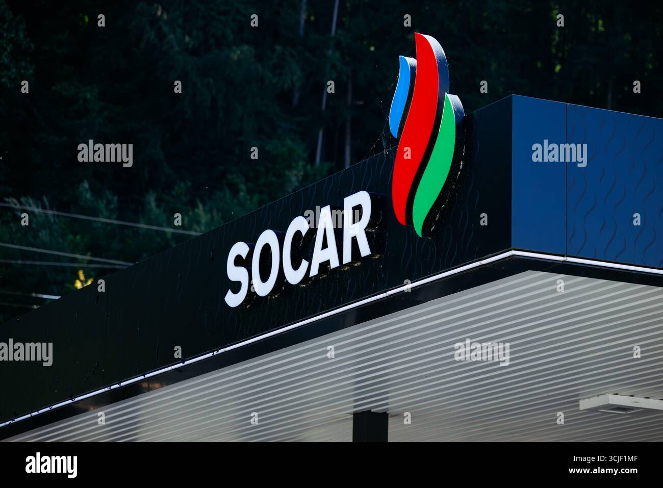 Faaker SEE, Austria - 1 settembre 2025: Il cartello del distributore di benzina SOCAR presenta un logo colorato su alberi verdi, che mette in risalto l'energia contemporanea Foto Stock