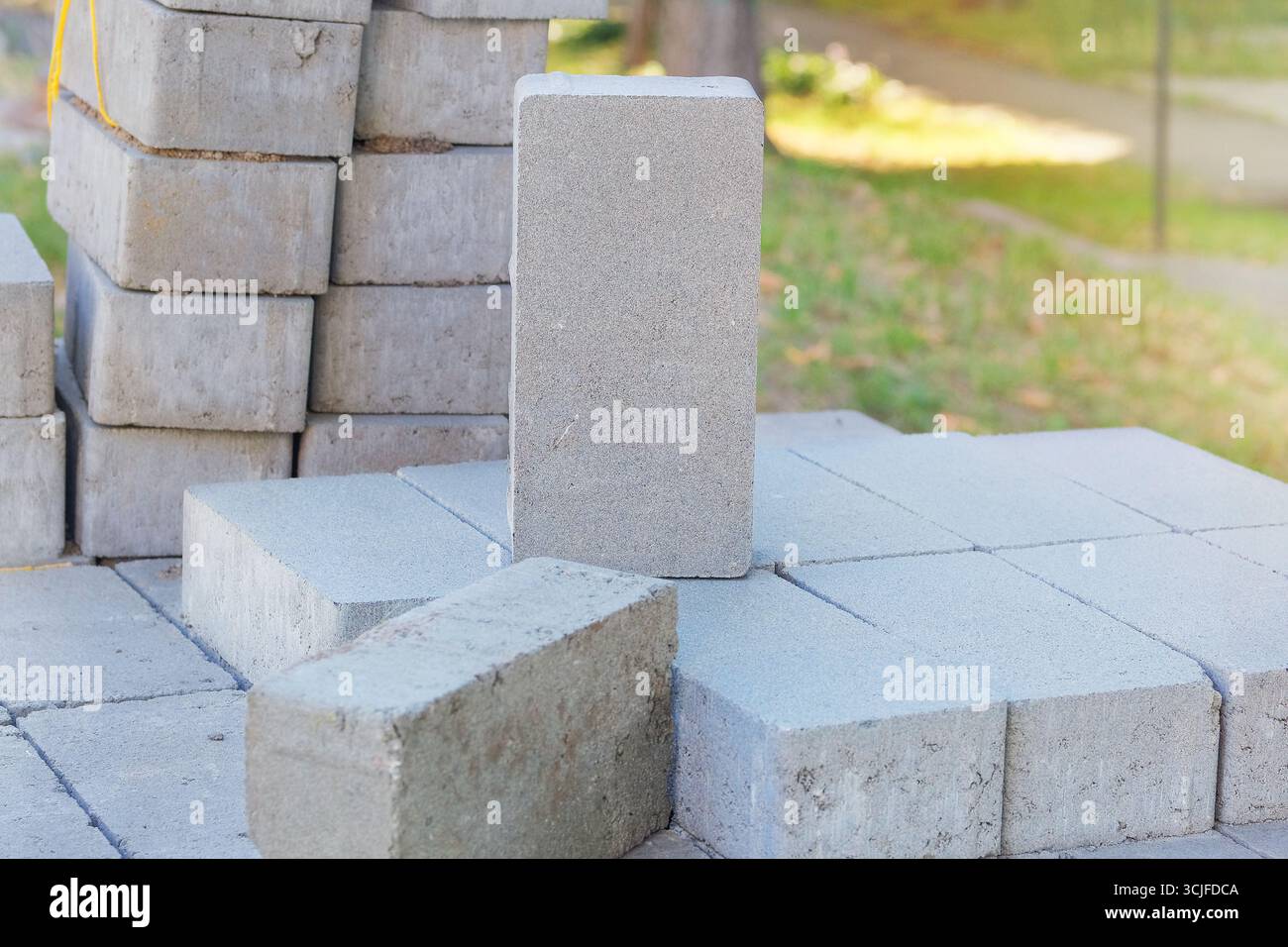 Blocchi grigi. Pietre per pavimentazione marciapiede impilate. Testurizzati e pronti per la costruzione. Materiale da costruzione. Costruzione di edifici. Foto Stock