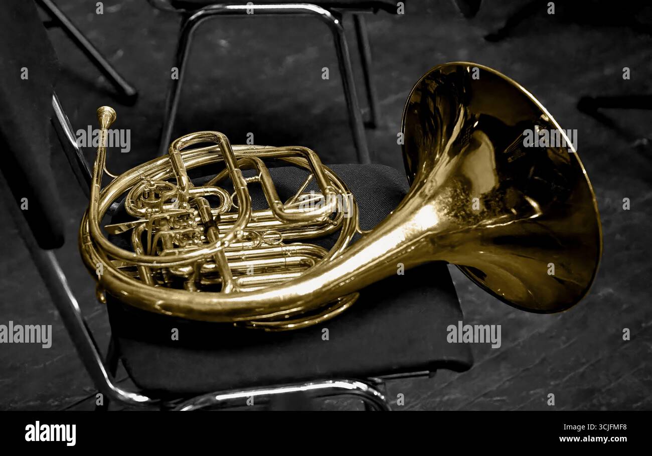 Immagine di un corno di strumenti musicali in ottone sdraiato su una sedia Foto Stock
