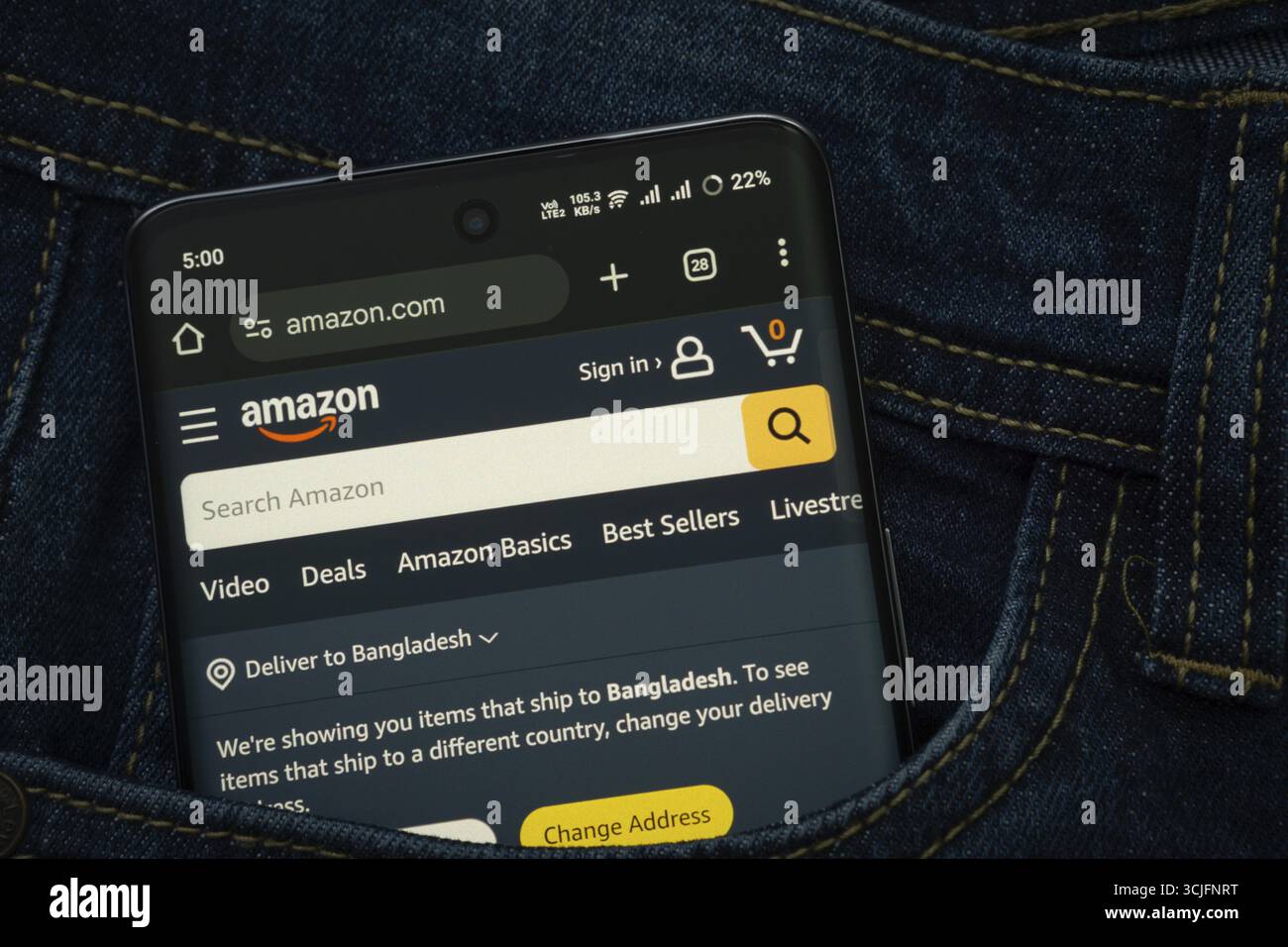 Dhaka, Bangladesh- 15 giugno 2025: Uno smartphone con l'interfaccia Web Amazon.com sbuca fuori da una tasca in denim Foto Stock