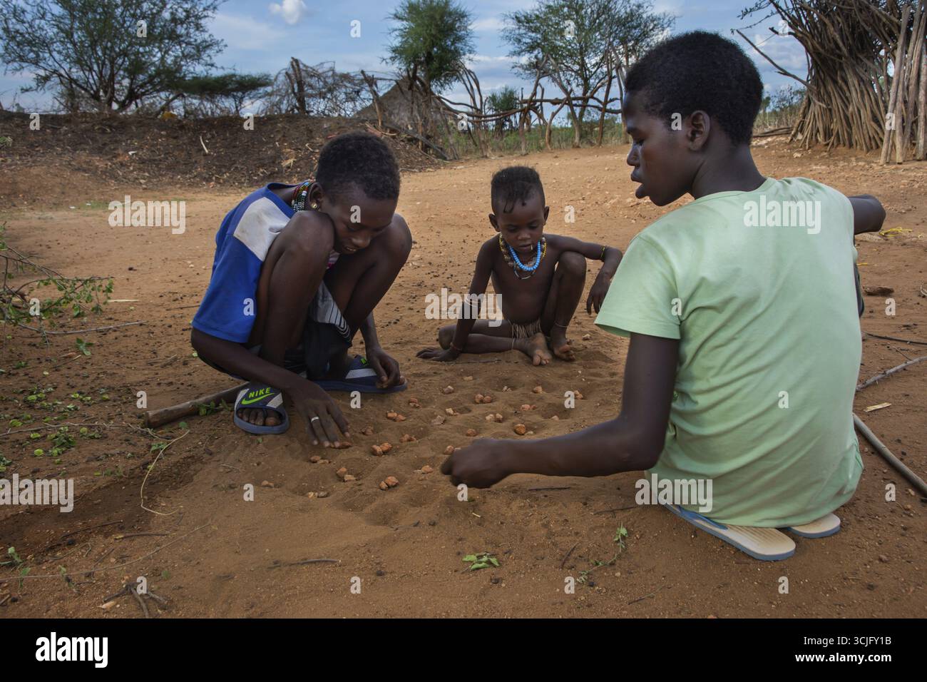 Turmi, Etiopia - Nov 2018: Hamer tribù ragazzi giocando a un gioco con pietre in terra. Valle dell'Omo Foto Stock