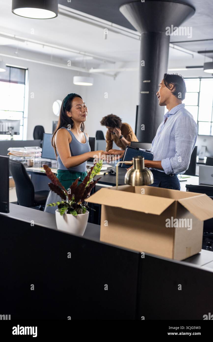 Colleghi che discutono di progetti in un ufficio moderno, condividono idee e collaborano Foto Stock