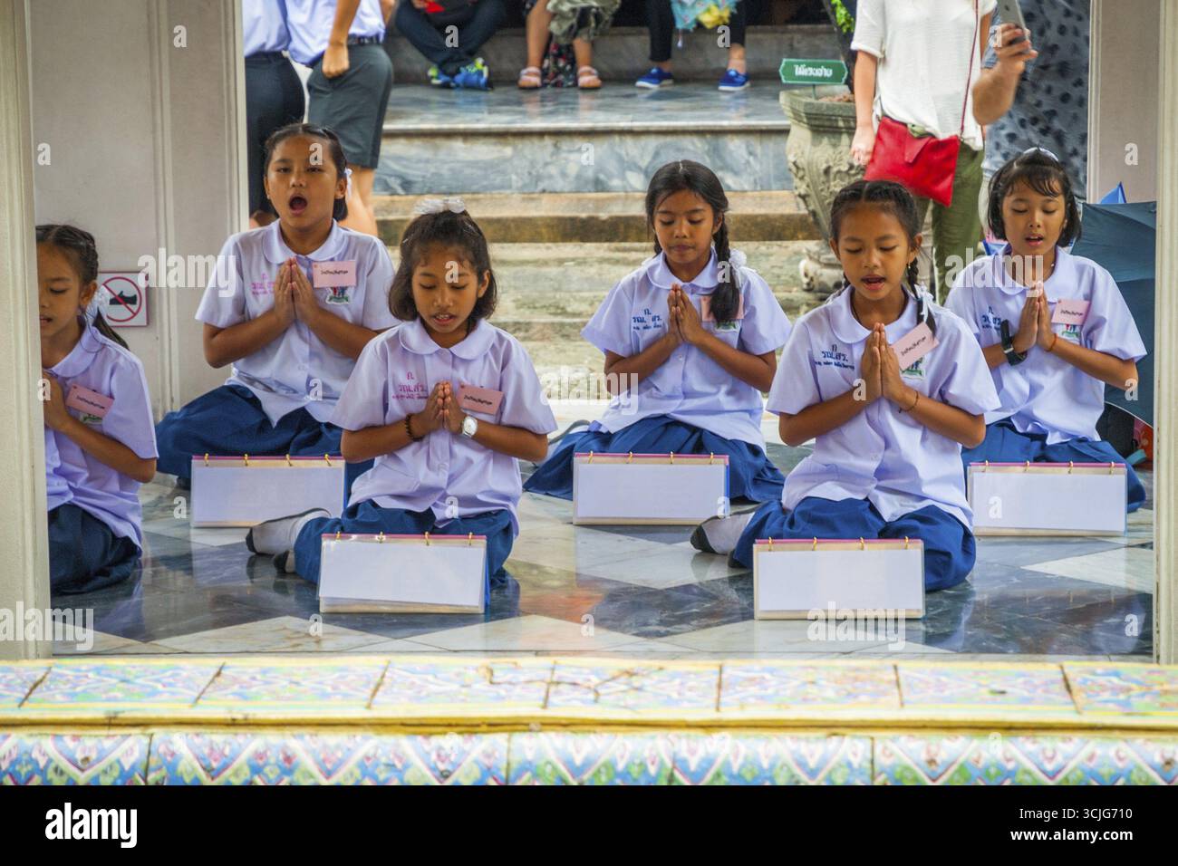 Bangkok, Thailandia - Sep 11, 2015: scuola i bambini a pregare e cantare al Wat Phra Kaew Tempio del Buddha di smeraldo, Bangkok Foto Stock
